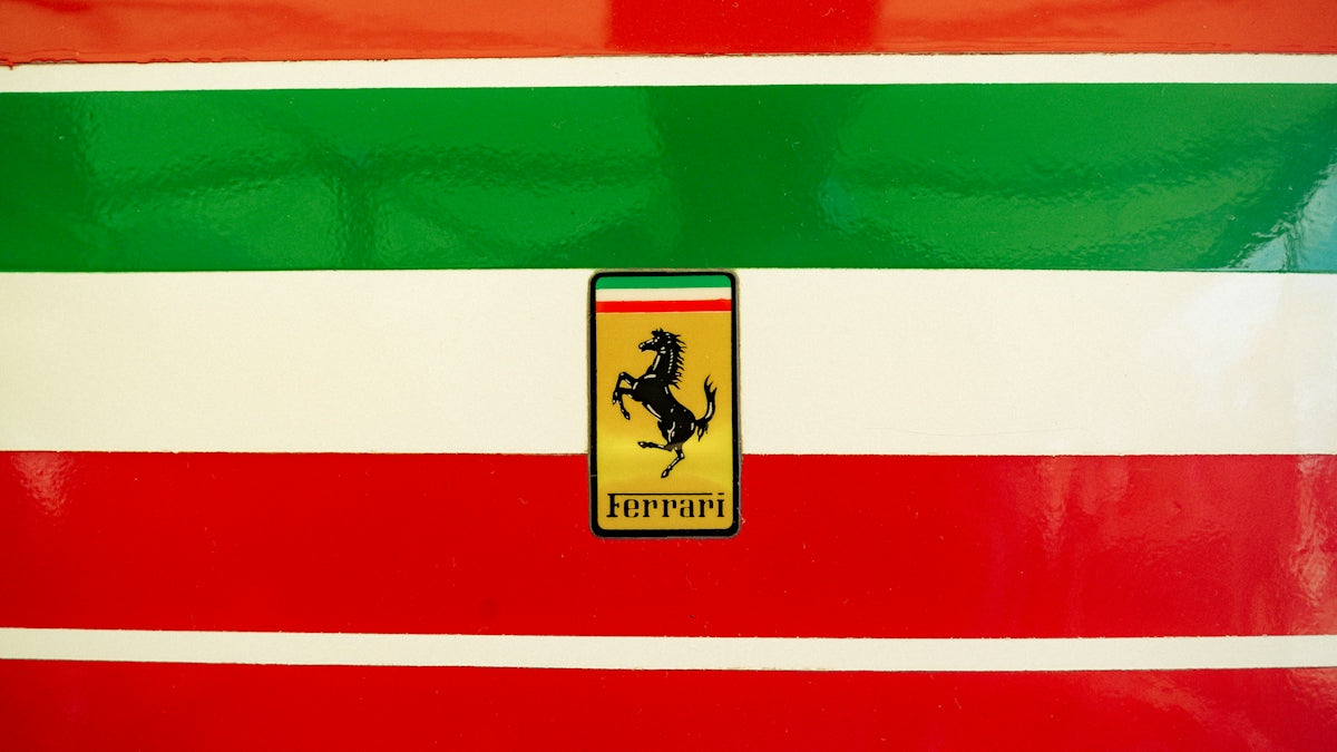 Ferrari logo on red, white, and green stripes