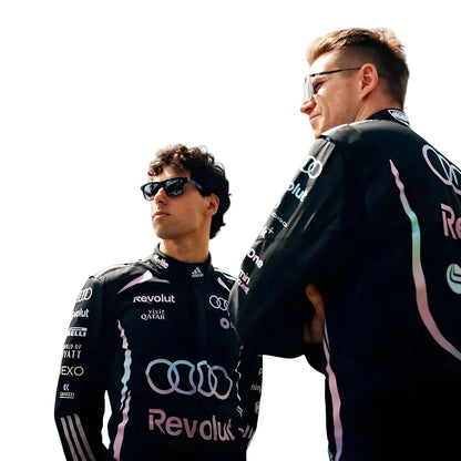 Two individuals wearing Audi racing suits with visible branding on a white background